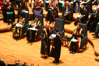 Tim receives his degree at his graduation ceremony
