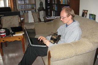Daniel with a computer and a cat in Cyprus
