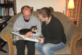 Daniel and Becky plus cat looking at photo album in Cyprus
