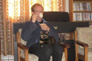 Daniel drinking Cyprus coffee, with a cat on his lap